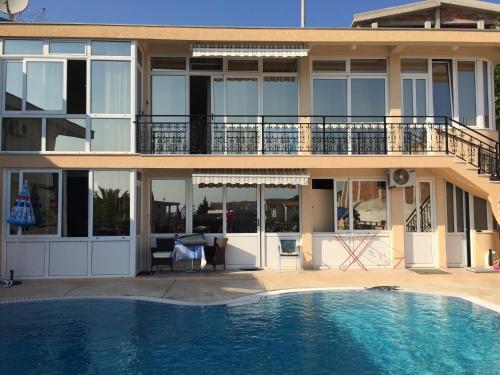 a house with a swimming pool in front of a building at Apartments Nensy in Bar