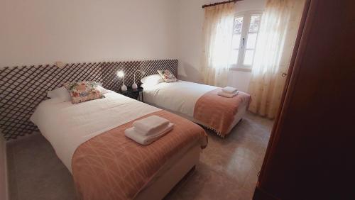 1 dormitorio con 2 camas y ventana en Vivenda Atanázio By Férias com Sol en Loulé