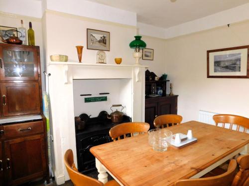 a dining room with a table and a fireplace at Annies, 30 Station Road in Sheringham