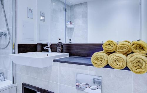 uma casa de banho com lavatório e toalhas num balcão em Luxury 2 bed flat in a new block in East Acton em Londres