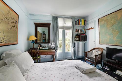 a bedroom with a bed and a desk and a television at "Maison 1850 Paris 18" Chambre G avec terrasse et parking en option in Paris