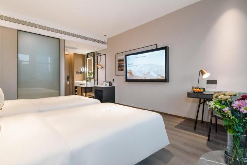 a hotel room with two beds and a flat screen tv at Atour Hotel Shenyang Zhongshan Plaza in Shenyang