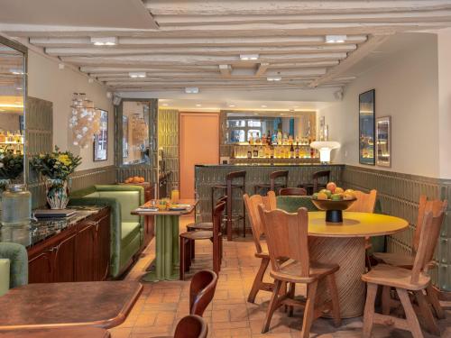 restauracja ze stołami i krzesłami oraz bar w obiekcie Hôtel Saint-André des Arts w Paryżu