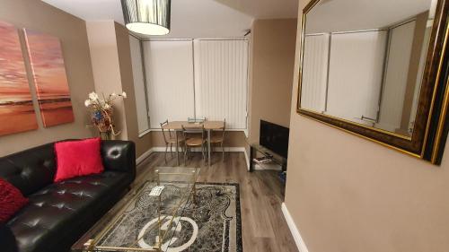a living room with a leather couch and a table at The Savile - Luxury Apartment Leeds - Your Next Stay in Leeds
