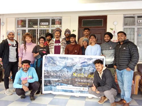 een groep mensen die poseren voor een foto met een banner bij Benus Darjeeling Home A Backpacker Hub in Darjeeling