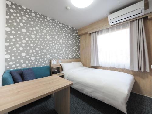 a hotel room with a bed and a window at Tabino Hotel EXpress Narita in Narita