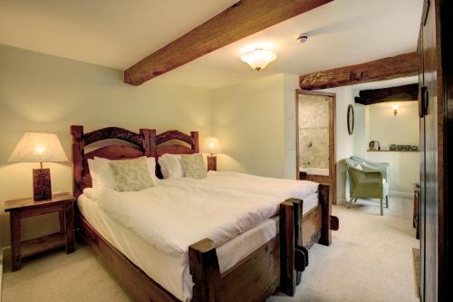 a bedroom with a large bed with a wooden headboard at Lowthwaite B&B in Watermillock