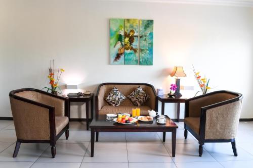 a living room with two chairs and a table with food on it at Portaluna Hotel & Resort in Jounieh