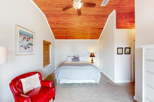 墨西哥海灘的住宿－Sea Turtle Cove，一间卧室配有一张床和一张红色椅子