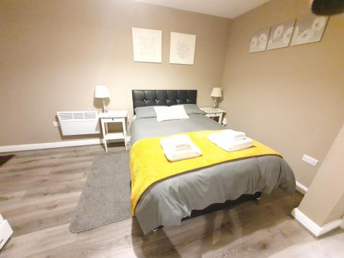 a bedroom with a bed with a yellow blanket at The Savile - Luxury Apartment Leeds - Your Next Stay in Leeds