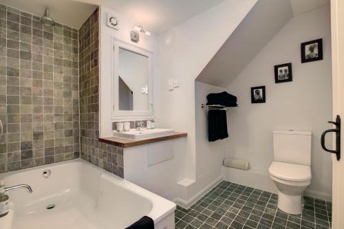 a bathroom with a tub and a toilet and a sink at Lowthwaite B&B in Watermillock