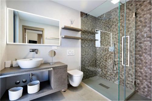 ein Bad mit einem Waschbecken, einem WC und einer Dusche in der Unterkunft Villa Damian in Rajki