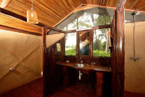 łazienka z umywalką i oknem w obiekcie Migunga Tented Camp w Mto wa Mbu