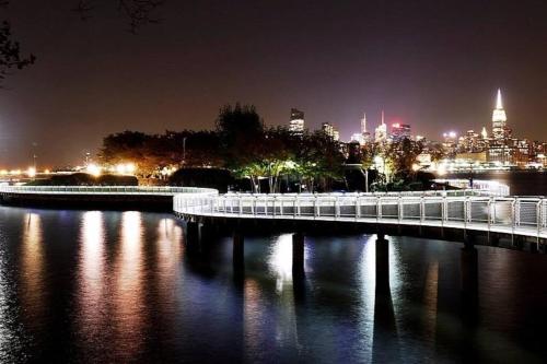 a bridge over a river with a city at night at Sage Stay by the Train, We Pay Half Your Parking, Sleeps 10 and Central to Tons of Eating Spots and Nightlife in Hoboken