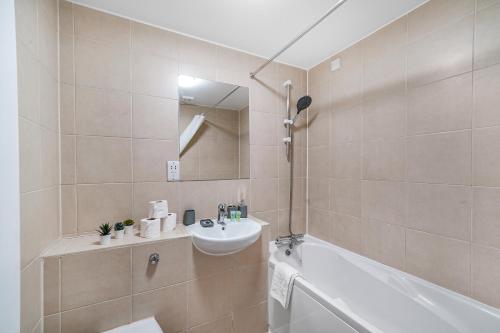 a bathroom with a sink and a toilet and a tub at Central Hackney Abode - Balcony in London