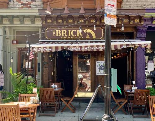 a restaurant with tables and chairs in front of a building at Sage Stay by the Train, We Pay Half Your Parking, Sleeps 10 and Central to Tons of Eating Spots and Nightlife in Hoboken