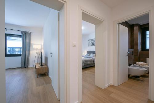 a bedroom with a bed and a bathroom with a tub at Boutique Apartments in Lugano