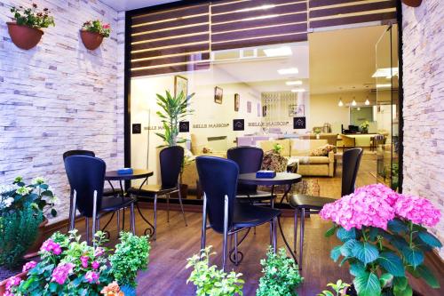una sala de espera con mesas, sillas y flores en Belle Maison Hotel&Residence, en Estambul