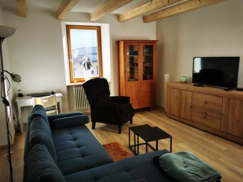 sala de estar con sofá azul y TV en Appartamento sci & laghi "Tre Fontane", en Tione di Trento