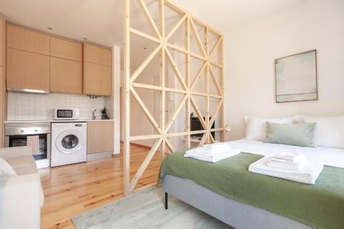 a small room with a bed and a kitchen at Campolide Charm Apartments in Lisbon