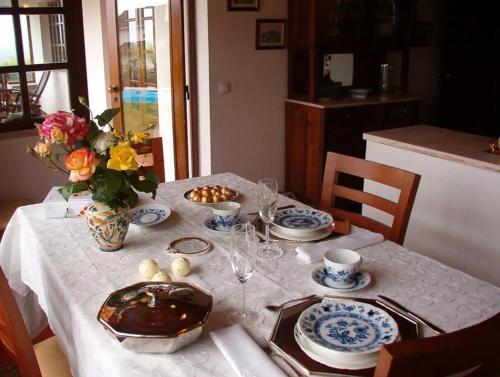 a table with a white table cloth and a vase of flowers at Casa do Moinho in Ulgueira