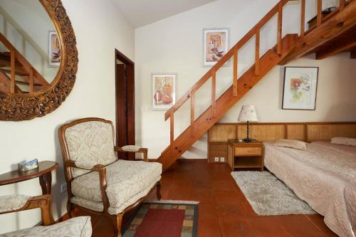 a bedroom with a staircase and a bed and a chair at Casa do Moinho in Ulgueira