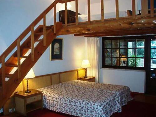 a bedroom with a large bed and a staircase at Casa do Moinho in Ulgueira