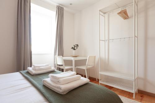 sypialnia z dwoma ręcznikami na łóżku ze stołem w obiekcie Campolide Charm Apartments w Lizbonie