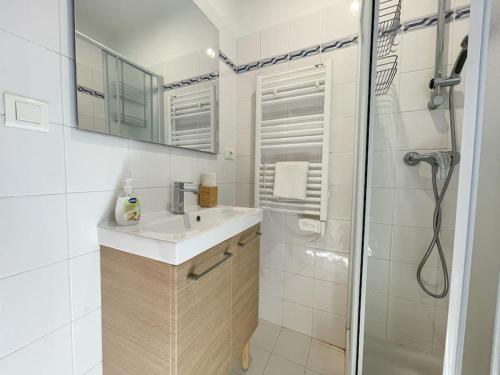 een witte badkamer met een wastafel en een douche bij Le calmette in Beausoleil