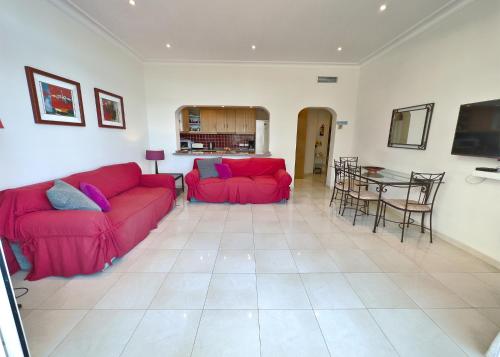 uma sala de estar com um sofá vermelho e uma mesa em Skol 2A Amazing 2 Bedroom Apartment Skol Marbella em Marbella