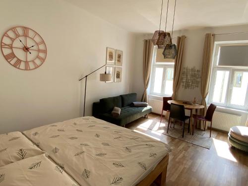 a bedroom with a bed and a chair and a clock at Atelier Lomani in Vienna