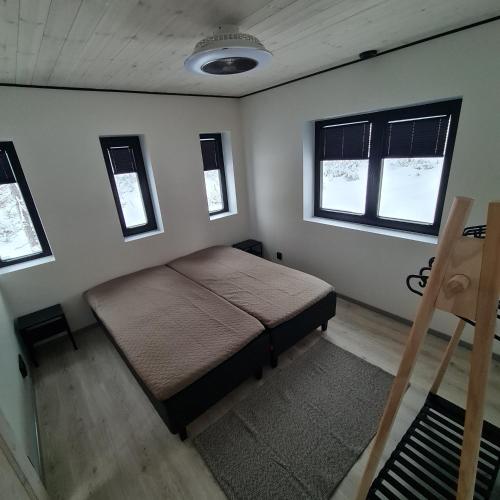 sypialnia z łóżkiem w pokoju z oknami w obiekcie Iso-Syöte Villa Remo w mieście Syöte