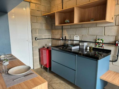 a kitchen with a sink and a red refrigerator at Studios in Serra Negra