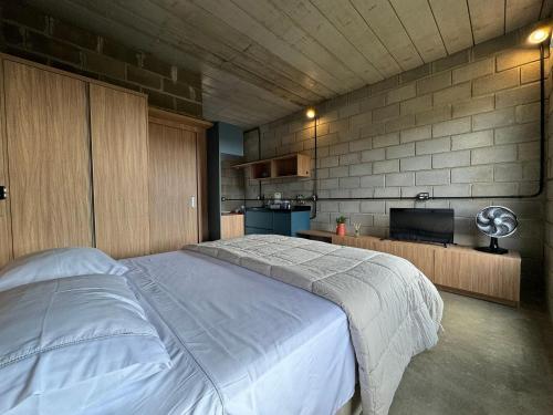 um quarto com uma cama grande e uma cozinha em Studios em Serra Negra