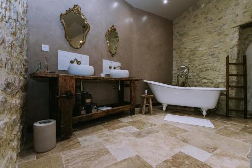 une salle de bain avec deux lavabos et une baignoire dans l'établissement Maison Guy, à Saint-Bauzély