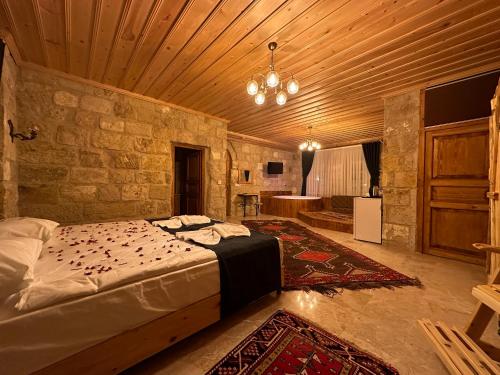 a bedroom with a bed and a stone wall at Tantan Cappadocia House in Avcılar