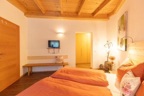 um quarto com uma cama e uma televisão na parede em Apartment Eckstoa em Abtenau