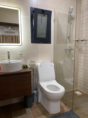y baño con aseo, lavabo y ducha. en Aquaview Apartments, en Bijilo