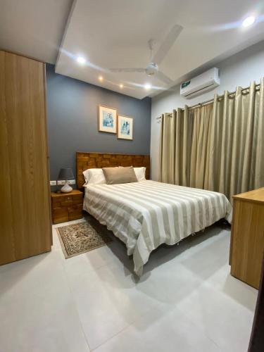 1 dormitorio con 1 cama con colcha blanca en Aquaview Apartments, en Bijilo