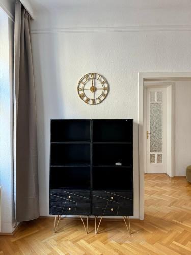 a living room with a clock on the wall at Atelier Lomani in Vienna