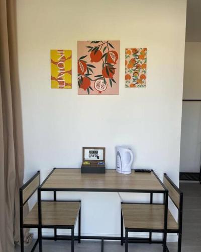 a table with two chairs and a clock on it at Les Chalets du Mancel : Studio June - 24H du Mans - Bouleries Jump - in Parence