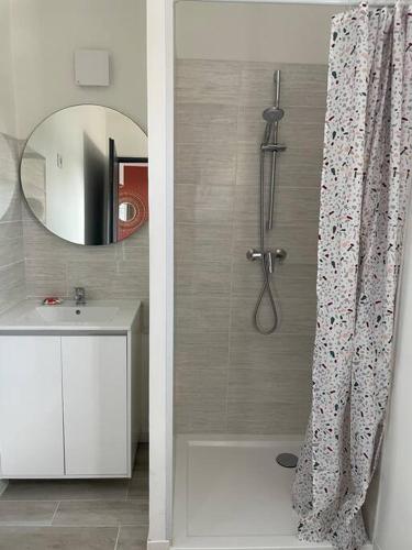 y baño con ducha, lavabo y espejo. en Les Chalets du Mancel : Studio June - 24H du Mans - Bouleries Jump -, en Parence