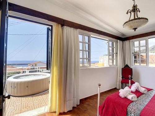 1 dormitorio con bañera y ventana grande en Moreira House by Atlantic Holiday, en Caniçal