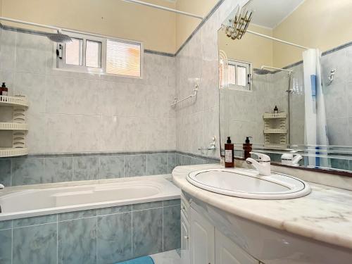 a bathroom with a tub and a sink and a bath tub at Moreira House by Atlantic Holiday in Caniçal