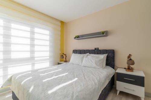 Un dormitorio con una cama grande y una ventana en Comfy Residence Flat 3 min to Mall of Antalya, en Antalya