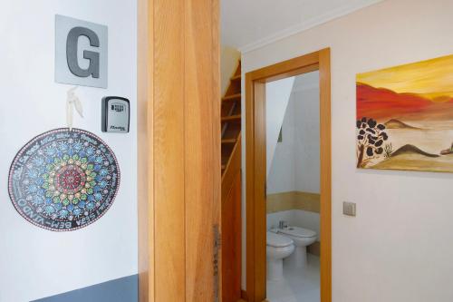 een badkamer met een toilet en een bord aan de muur bij Sun and Moon in Porto Santo