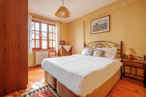 una camera da letto con un grande letto con lenzuola bianche di Villa with Garden 10 min to Sapanca Lake a İzmit