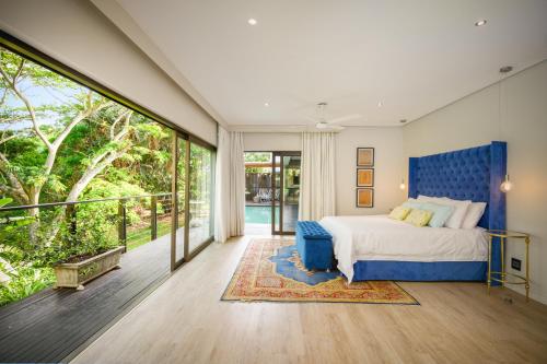a bedroom with a bed and a large window at Dunkirk Estate, Family Home in uMhlali