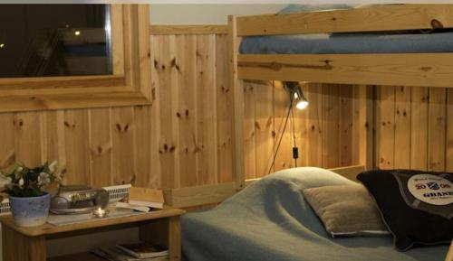 1 dormitorio con 1 cama y pared de madera en Årsunda Strandbad, en Årsunda