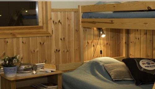 a bedroom with a bed and a wooden wall at Årsunda Strandbad in Årsunda